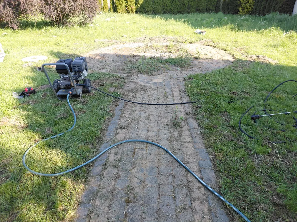 Brudna kostka brukowa z mchem i nalotem przed czyszczeniem